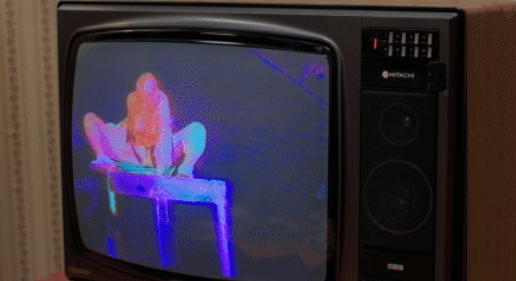 An old TV screen showing one of Bowery's performance in which he is squatting on a table.