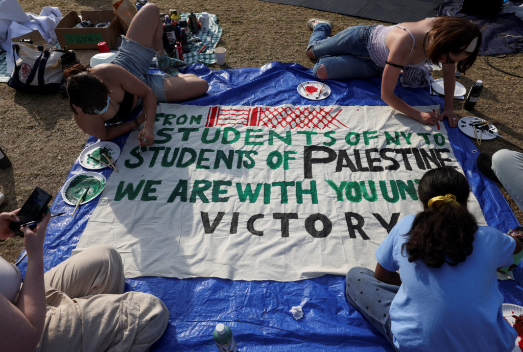 Students at a Palestine Solidarity encampment craft a banner.